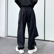 Unisex wearing black hakama pants back side view