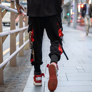 Man wearing red and black techwear pants adjustable straps