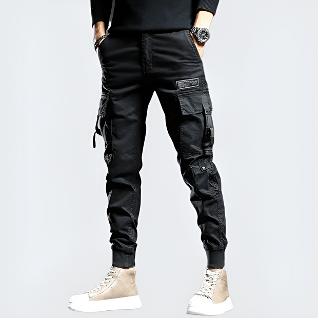 Man wearing black cyberpunk pants multiple pockets on both sides