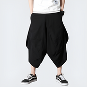 Man wearing black japanese harem pants multiple pockets on both sides