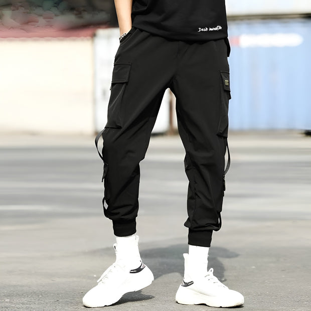 Man wearing black techwear track pants multiple pockets on both sides