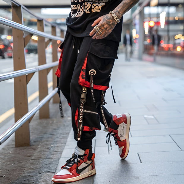 Man wearing red and black techwear pants elastic waistband left side