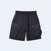 Techwear UK hidden pocket cargo shorts front view – man wearing black tactical summer shorts with hidden compartments, ideal for urban streetwear style, futuristic fashion, and everyday techwear utility.
