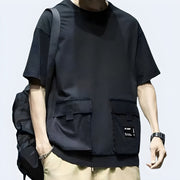 Techwear UK reflective pocket t-shirt front view – Man wearing futuristic techwear t-shirt with reflective chest pocket, modern streetwear style ideal for urban fashion lovers in the UK.