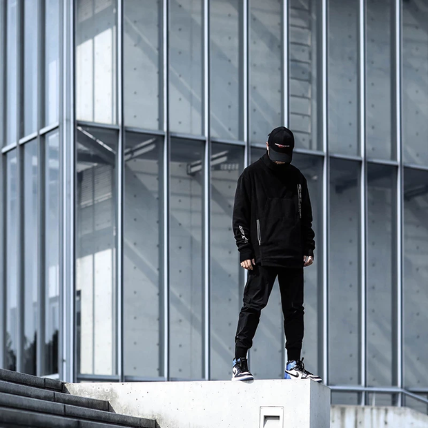 Man wearing black techwear turtleneck zipper pocket decorations